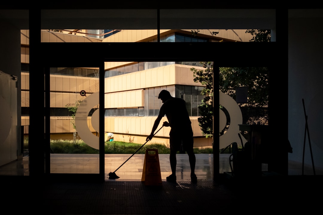 Startseite Man cleans floor at an entrance door.